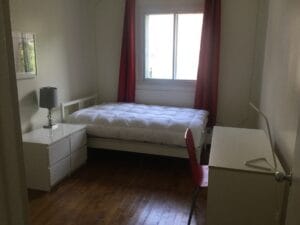 Chambre lumineuse avec lit et meubles modernes en bois clair pour un confort optimal.