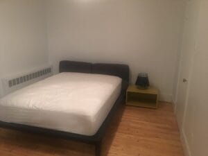Chambre meublée dans un appartement étudiant avec lit double confortable parquet lumineux et décor minimaliste idéal pour un logement d'étudiant recherchant simplicité.