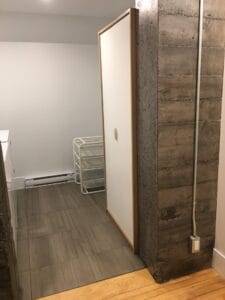 Chambre moderne avec mur en béton et porte coulissante blanche