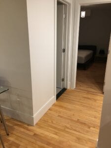 Vue intérieure d'un appartement étudiant incluant un couloir spacieux avec parquet en bois clair et accès à une chambre moderne bien aménagée.