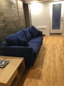 Sofa bleu moderne dans une chambre avec parquet en bois